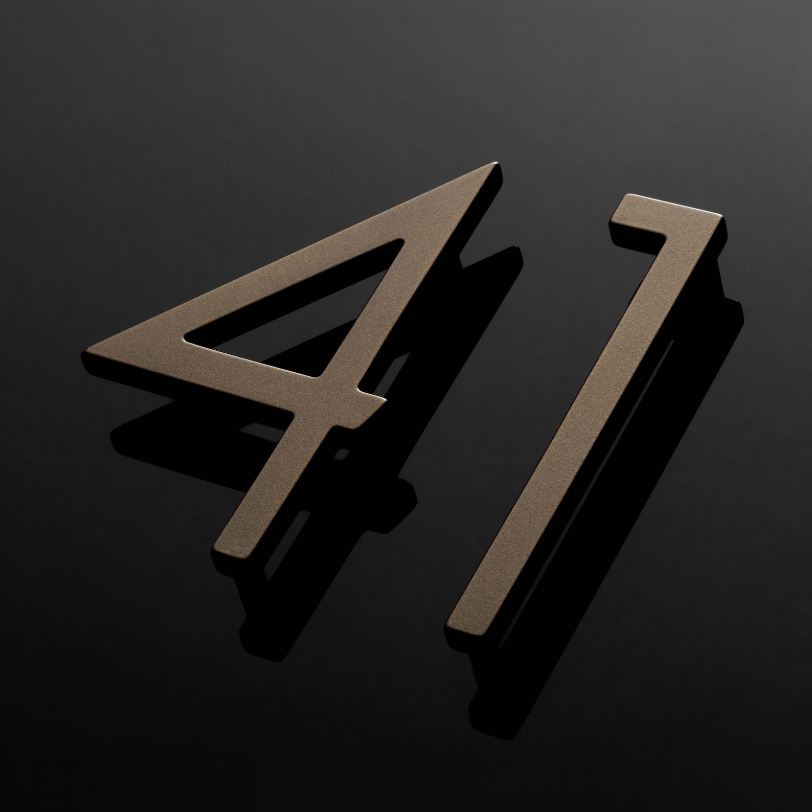 Apartment 41 — dimensional brass numerals surface-mounted on wall.